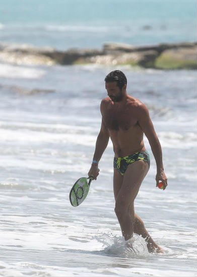 Gianluigi Buffon squeezes into a pair of budgie smugglers as he plays bat and ball with a pal on the beach