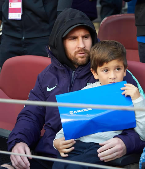 Lionel Messi seen without sling for first time after breaking arm as he sits beside son Thiago to watch Barcelona in El Clasico