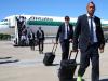 Arturo Vidal in dark suit and lime green trainers leads the Juventus players off the plane.
