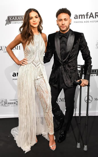 PSG ace Neymar kisses girlfriend Bruna Marquezine as he hobbles on red carpet on crutches at Sao Paulo charity event