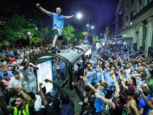 Manchester City fans smash up cop van and clash with riot police after side wins Champions League and completes treble