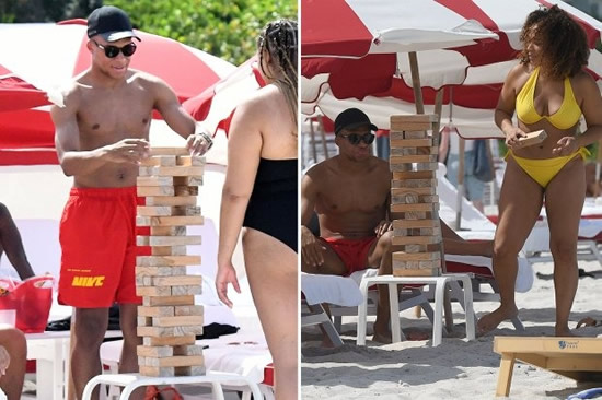 Kylian Mbappe brushes off transfer rumours as he plays giant Jenga on a beach with bikini-clad woman during his holidays