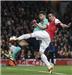 Arsenal's Robin van Persie kicks the ball against Barcelona's Gerard Pique during their Champions League soccer match at the Emirates stadium in north London